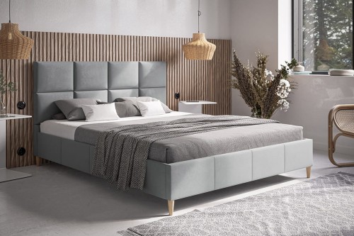 Szare-łóżko-tapicerowane-na-drewnianych-nóżkach